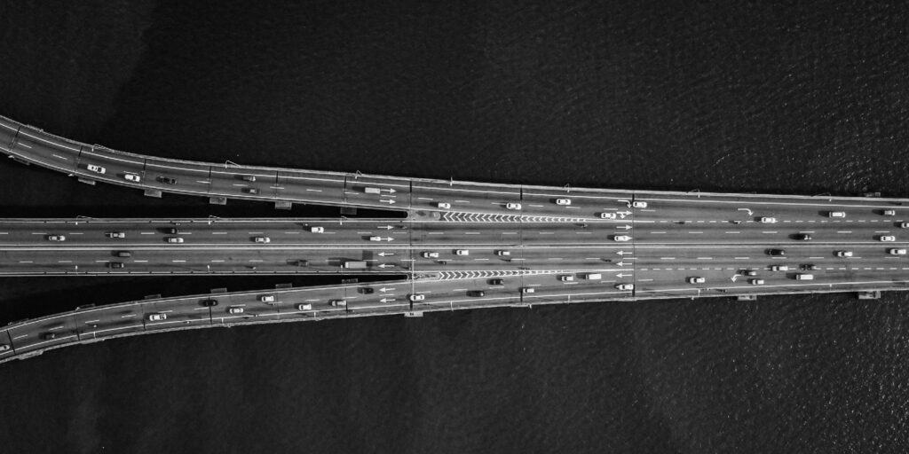 A black and white photo of a bridge over a body of water.