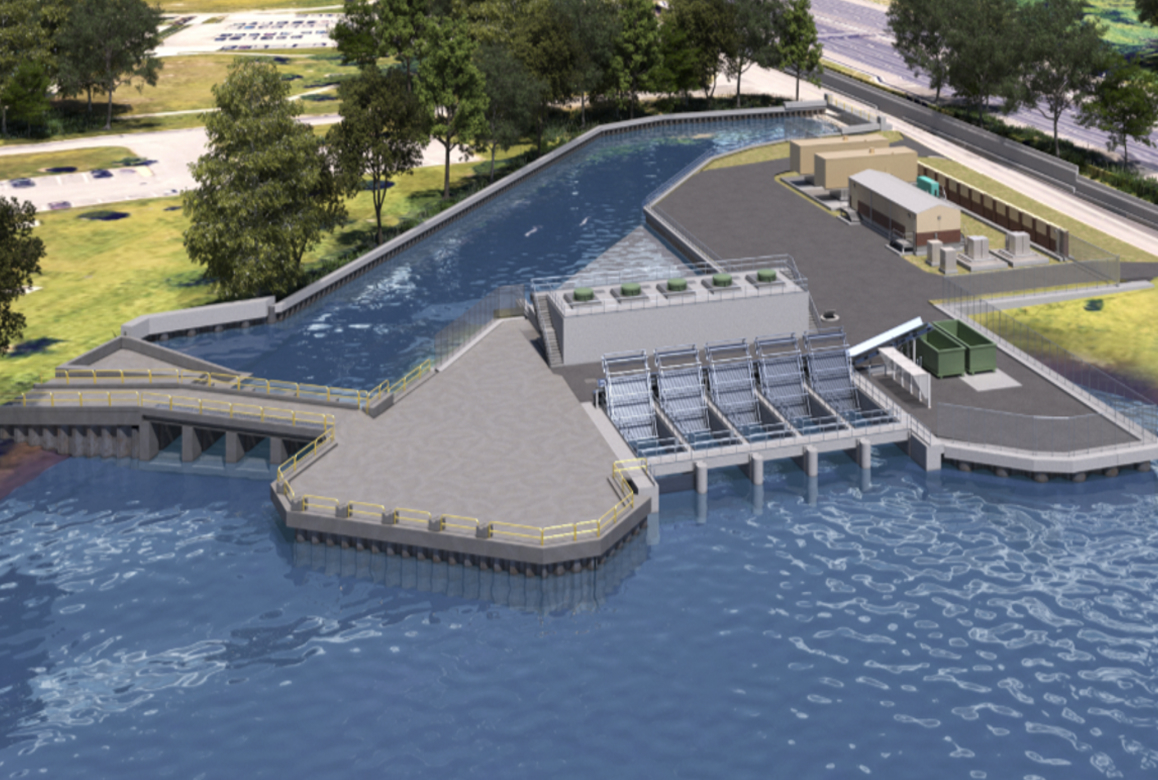 Aerial view of a water treatment or dam facility with a long concrete platform extending into a blue body of water and trees nearby.