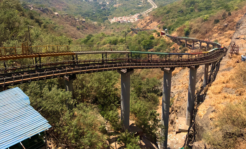 A photograph of the Funicular at Hajimalang, showing the railway tracks ascending a steep, rocky hillside supported by tall pillars, a finalist project by Indian Railways.