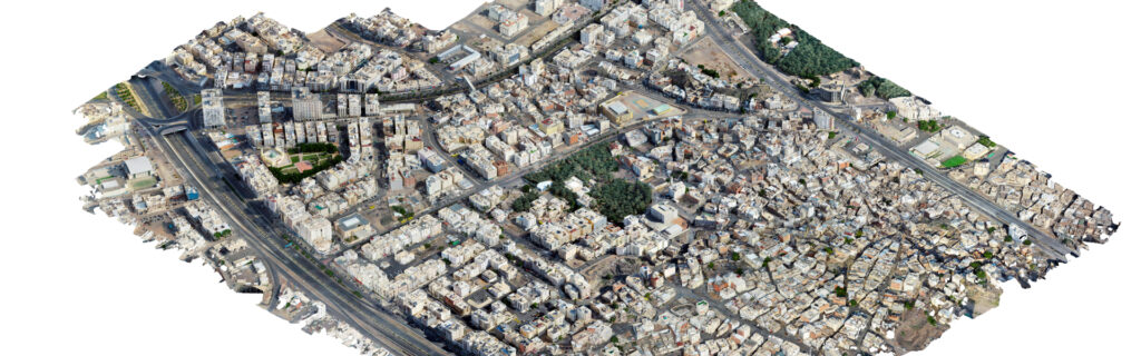 Aerial view of a densely built urban area with tightly packed buildings, intersecting roads, and small green spaces scattered throughout, ideal for Urban Analytics using the Manarah Urban Data Platform.