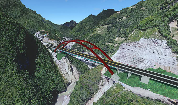 A red-arched bridge spans a deep gorge between green, forested mountains with steep rocky slopes visible on either side.