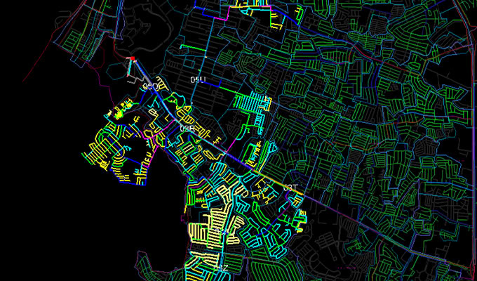 A digital map displays a network of multicolored, outlined streets and parcels, with a concentration of yellow lines in the lower left area against a black background.