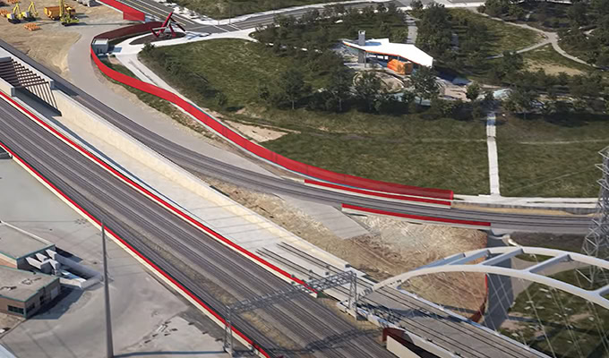 Aerial view of the partially constructed Ontario Line railway with tracks, a bridge, and construction equipment near a grassy area and trees highlights effective information management on-site.