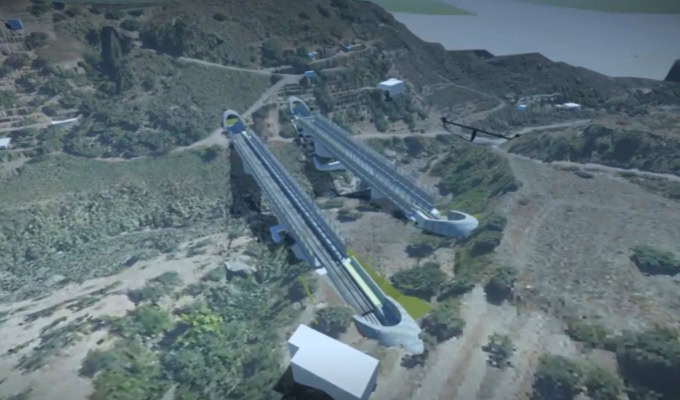 Aerial view of two parallel bridge structures under construction in a hilly, green landscape with scattered buildings nearby, showcasing construction innovation and digital construction methods.