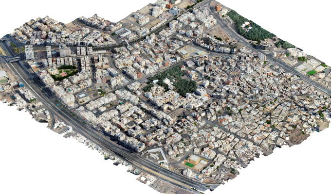 Aerial view of a densely built urban area with clustered buildings, intersecting roads, and some green spaces—ideal for Urban Analytics using the Manarah Urban Data Platform.
