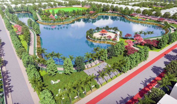 Aerial view of a landscaped park at Atal Puram Township, showcasing a masterplan with a large lake, central island gazebo, green lawns, walking paths, trees, and recreational areas.